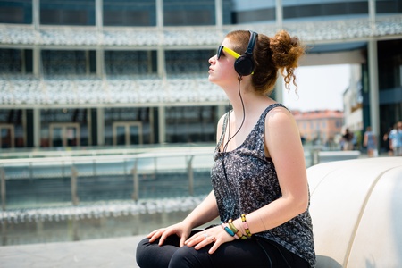 beautiful stylish modern young woman listening to music in the cityの写真素材