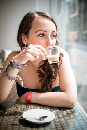 young beautiful woman drinking coffee at the coffee barの写真素材