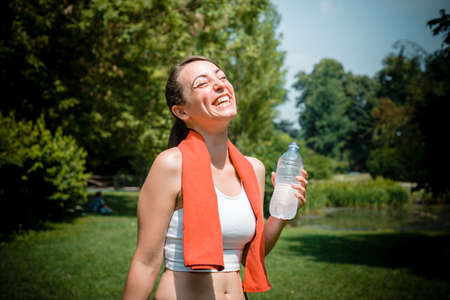 beautiful woman fitness drinking water at the parkの写真素材