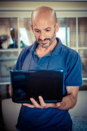 middle age man using notebook at homeの写真素材