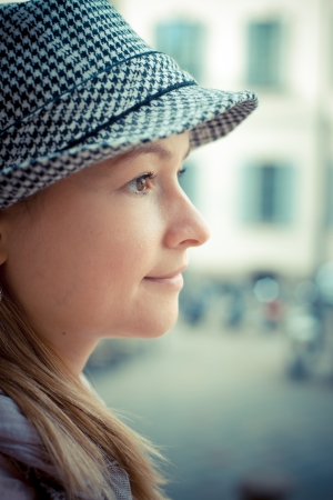 beautiful blonde woman with hat in the cityの写真素材