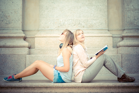 two beautiful blonde woman relaxing in the cityの写真素材