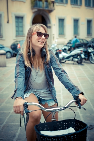 two beautiful blonde women shopping on bike in the cityの写真素材