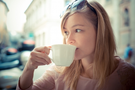 beautiful blonde woman having breakfast at the bar in the cityの写真素材
