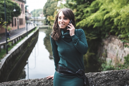 beautiful woman with turtleneck on the phone in the city autumnの写真素材