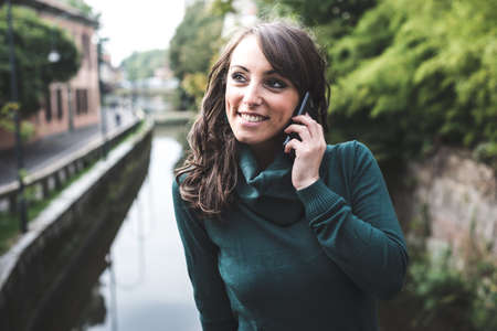 beautiful woman with turtleneck on the phone in the city autumnの写真素材