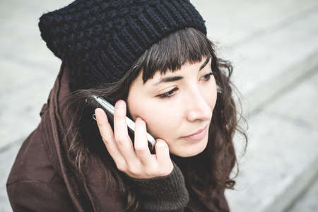 beautiful young woman on the phone in the city autumnの写真素材