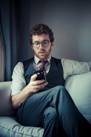elegant attractive fashion hipster man on the phone at homeの写真素材