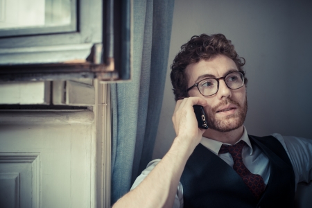 elegant attractive fashion hipster man on the phone at home