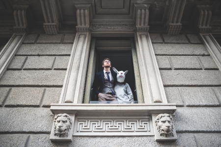 elegant attractive fashion hipster man with rabbit woman appeared at the windowの写真素材