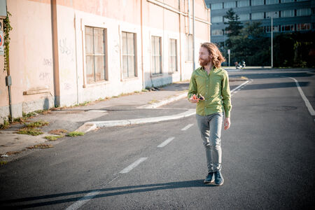 stylish hipster model with long red hair and beard lifestyle in the streetの写真素材