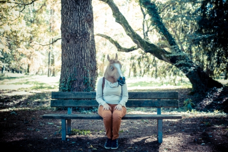 young hipster horse mask woman in the woodland autumnの写真素材