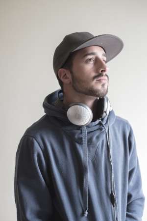 young stylish man listening to music on gray backgroundの写真素材
