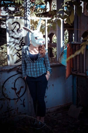 beautiful young blonde rabbit mask woman in an abandoned urban landscapeの写真素材
