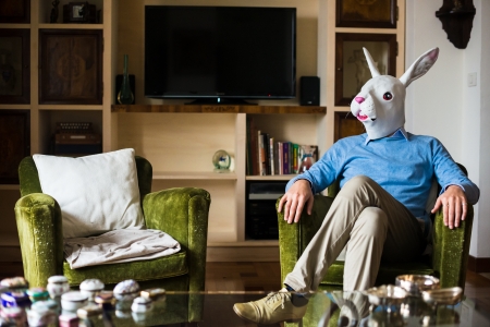 elegant business multitasking rabbit mask man using devices at home