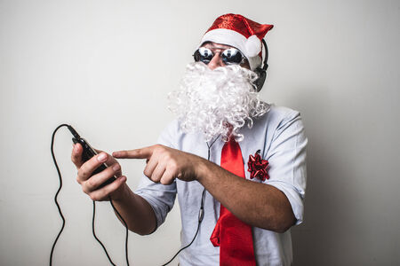 funny santa claus babbo natale listening music on white backgroundの写真素材