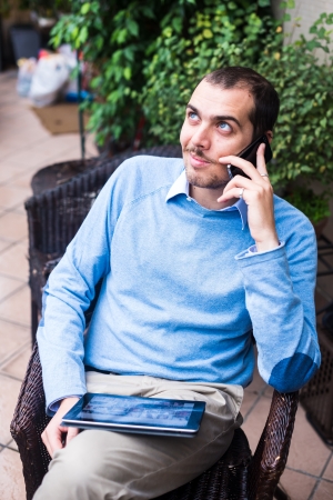 elegant business multitasking multimedia man using devices at homeの写真素材