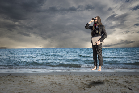 Stylish elegant dreadlocks businessman binocular in sea landscapeの写真素材