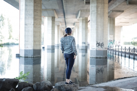 beautiful young blonde hipster woman listening music in urban landscapeの写真素材