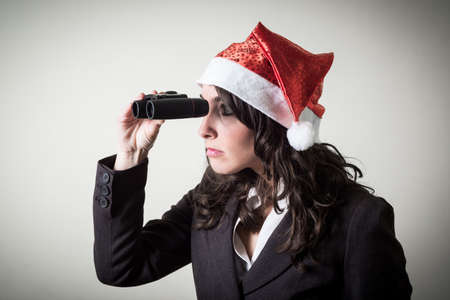 funny christmas businesswoman with binoculars on white backgroundの写真素材