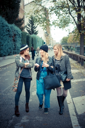 three friends woman on the phone in the streetの写真素材