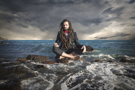 Stylish elegant dreadlocks businessman levitating in sea landscapeの写真素材