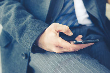 close up of businessman hand typing on smart phoneの写真素材