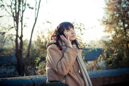 beautiful young woman listening to music headphones  in the city winterの写真素材