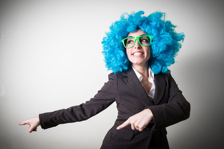 funny blue wig beautiful young businesswoman on gray の写真素材