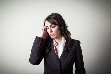 stressed beautiful young businesswoman on gray の写真素材