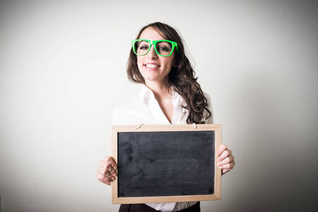 beautiful young businesswoman holding blackboard on gray の写真素材