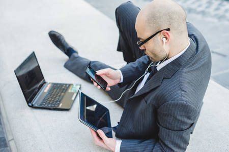 successful elegant fashionable businessman using tablet  in business districtの写真素材