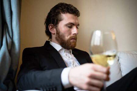 handsome bearded hipster elegant man with glass of wine