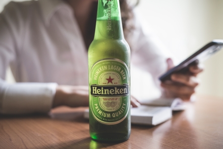 MILAN, ITALY - JANUARY 16, 2014: Woman drinking heineken beer glass bottle 33 cl. Heineken...
