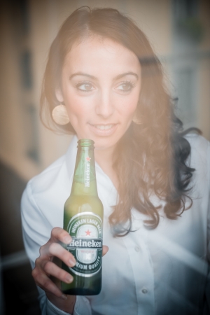 MILAN, ITALY - JANUARY 16, 2014: Woman drinking heineken beer glass bottle 33 cl. Heineken International is a Dutch brewing company, founded in 1864 in Amsterdam, famous all over the world.のeditorial素材
