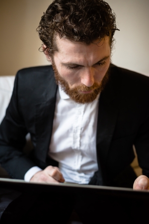 handsome bearded hipster elegant man using laptopの写真素材