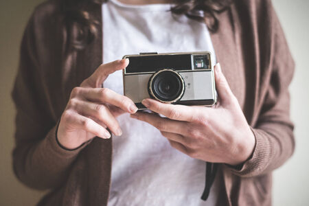 close up of hands woman with old camera at homeの写真素材