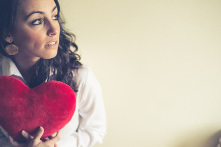 beautiful woman at home with heart for valentine's dayの写真素材