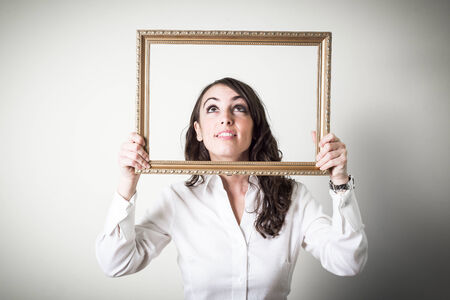 beautiful young businesswoman through ledge on gray backgroundの写真素材
