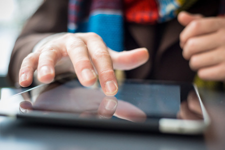 close up of hand and device tablet touching on the table at the barの写真素材