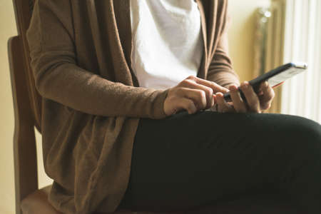 close up of hand woman typing on smart phone at homeの写真素材