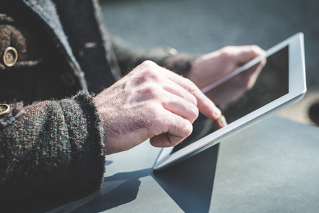 close up of hands man using tablet outdoorの写真素材