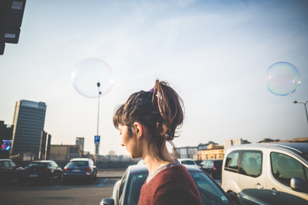 young beautiful hipster woman bubble blower in the cityの写真素材