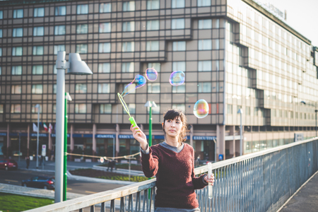young beautiful hipster woman bubble blower in the cityの写真素材