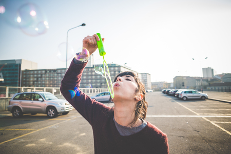 young beautiful hipster woman bubble blower in the cityの写真素材
