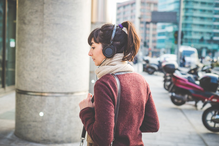 young beautiful hipster woman listening music with headphones in the cityの写真素材