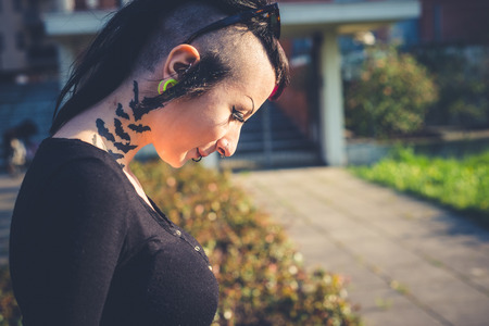 young beautiful punk dark girl in urban landscapeの写真素材