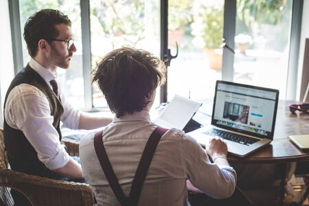 two young hipster stylish elegant men working with notebook and tablet at home 
