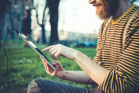 close up of man hands using tablet outdoorsの写真素材