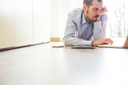 elegant business multitasking multimedia man using devices at homeの写真素材